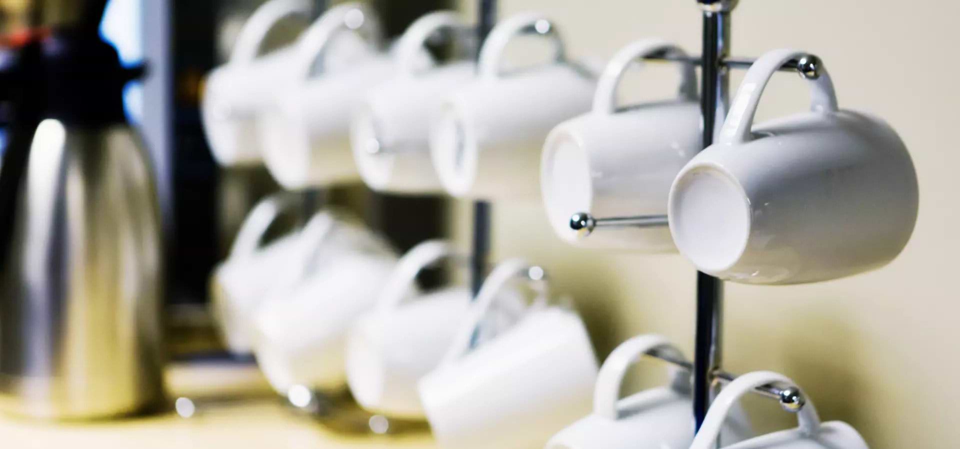 white-mugs-hanging-on-rack-in-office-breakroom
