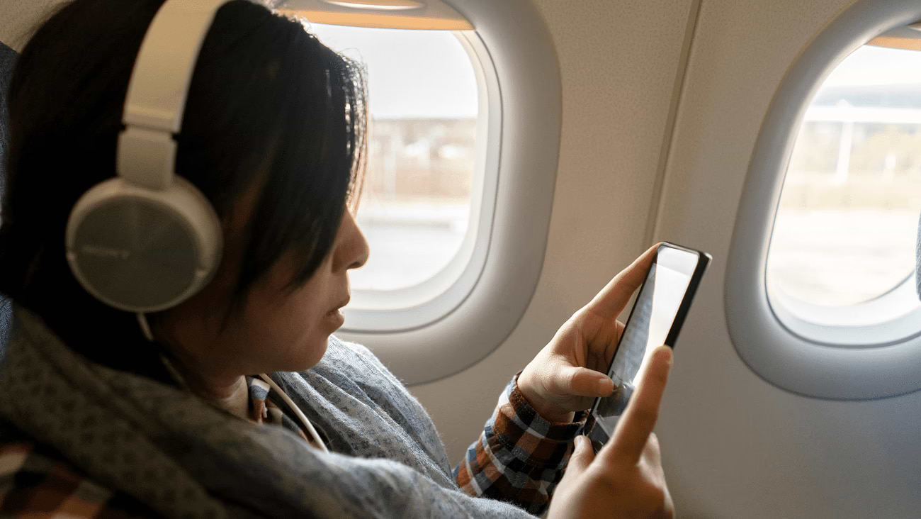 A woman on a plane plays on the phone using a surfing package