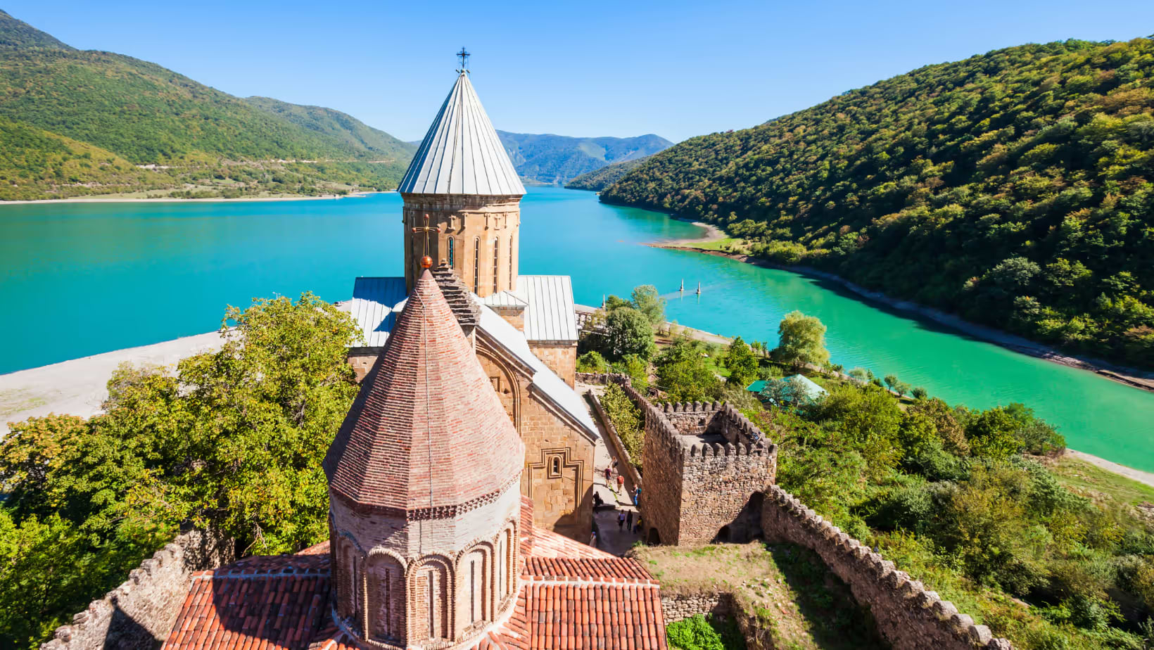 A Georgian castle against a blue lake