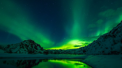 תמונה של נוף מושלג ושמים עם הזוה הצפוני כחלק מטיול באיסלנד