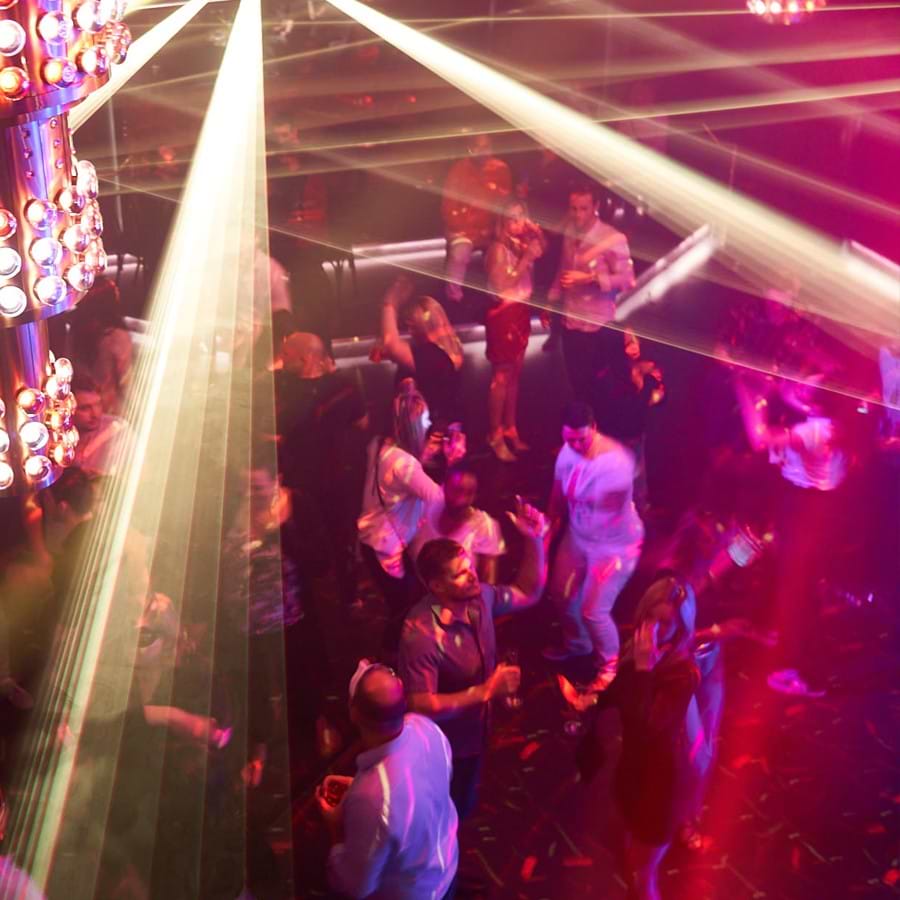 People dancing in a beautifully lit club environment